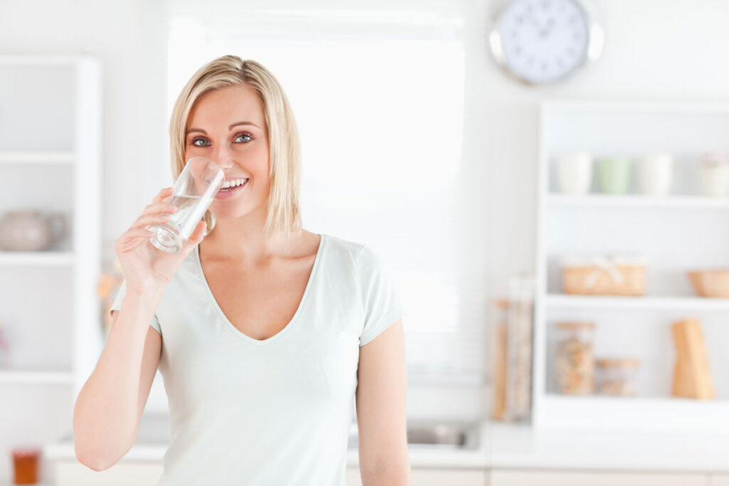 A lady drinking a glass of water